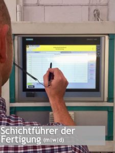 Mitarbeiter bedient Touchscreen-Panel in Produktionsanlage