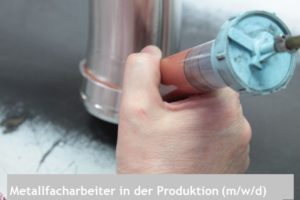Hand misst Metallbauteil mit Messschraube in der Produktion