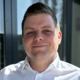 Porträt von Matthias Hofmann vor einem modernen Gebäude