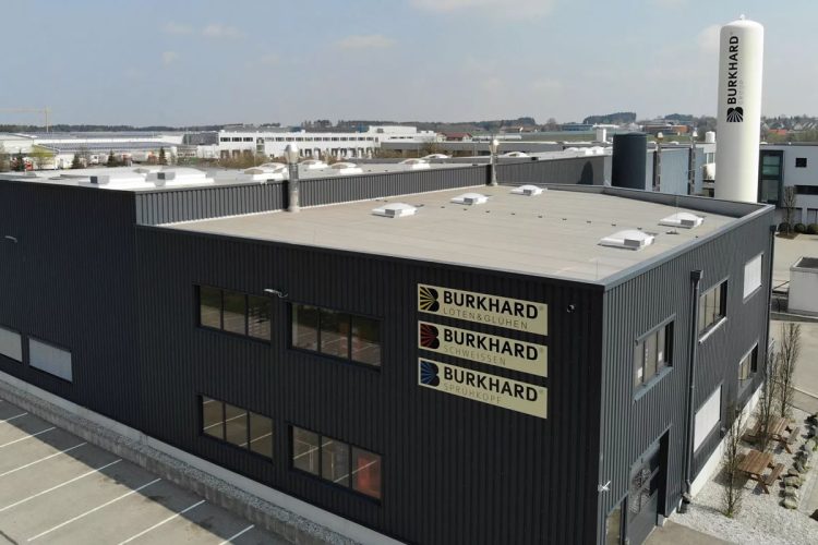 Firmengebäude der Burkhard Group mit Logos für Löten & Glühen, Schweißen und Sprühkopf