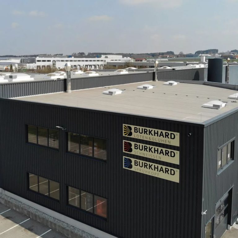 Firmengebäude der Burkhard Group mit Logos für Löten & Glühen, Schweißen und Sprühkopf